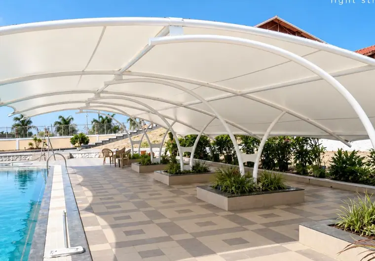 Marquesina blanca junto a una piscina y una terraza