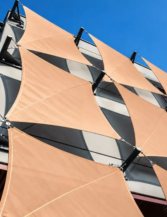 Fachada con paneles textiles geométricos en tonos cálidos
